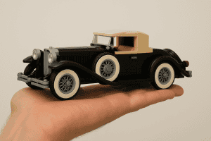 Classic vintage LEGO car model on a hand, showcasing intricate design and craftsmanship.
