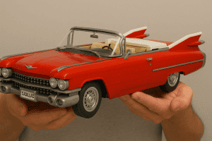 Red LEGO Cadillac toy car held in hands, detailed and realistic miniature model.