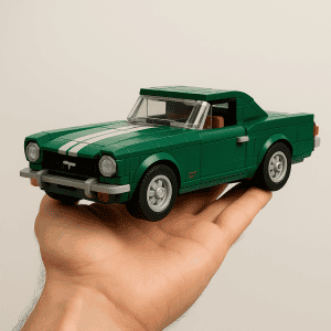 Green LEGO sports car with racing stripes on a person's hand.